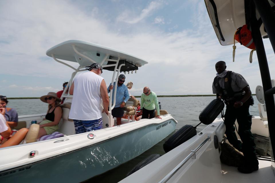 Game Warden Quintin Reed brings in his fenders after stopping a boat for a safety check on the Bull River.There were too many people for the boats listed capacity.