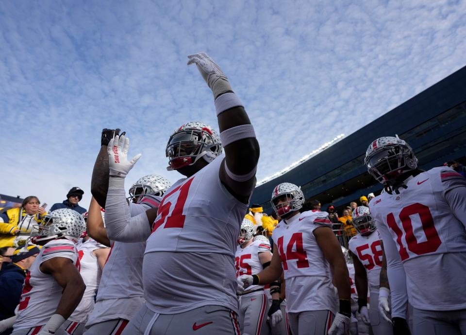 Nov. 25, 2023; Ann Arbor, Mi., USA;
 Ohio State Buckeyes defensive tackle Mike Hall Jr. (51) holds up his hands in an ÒOÓ as the team takes the field before SaturdayÕs NCAA Division I football game against the Michigan Wolverines at Michigan Stadium.