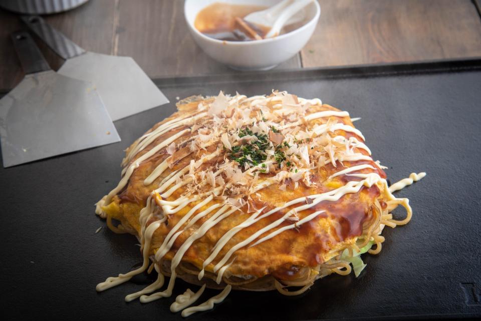 In Japan, the pancake is a savory entree, topped with meats, seafood, veggies and cheese.