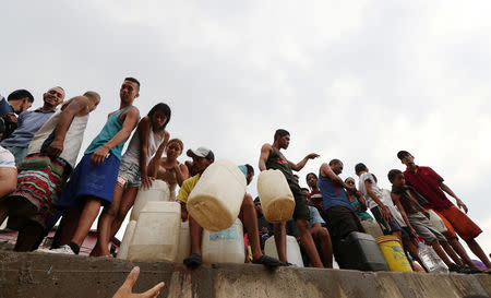 People collect water using containers in Caracas, Venezuela, March 31, 2019. REUTERS/Ivan Alvarado
