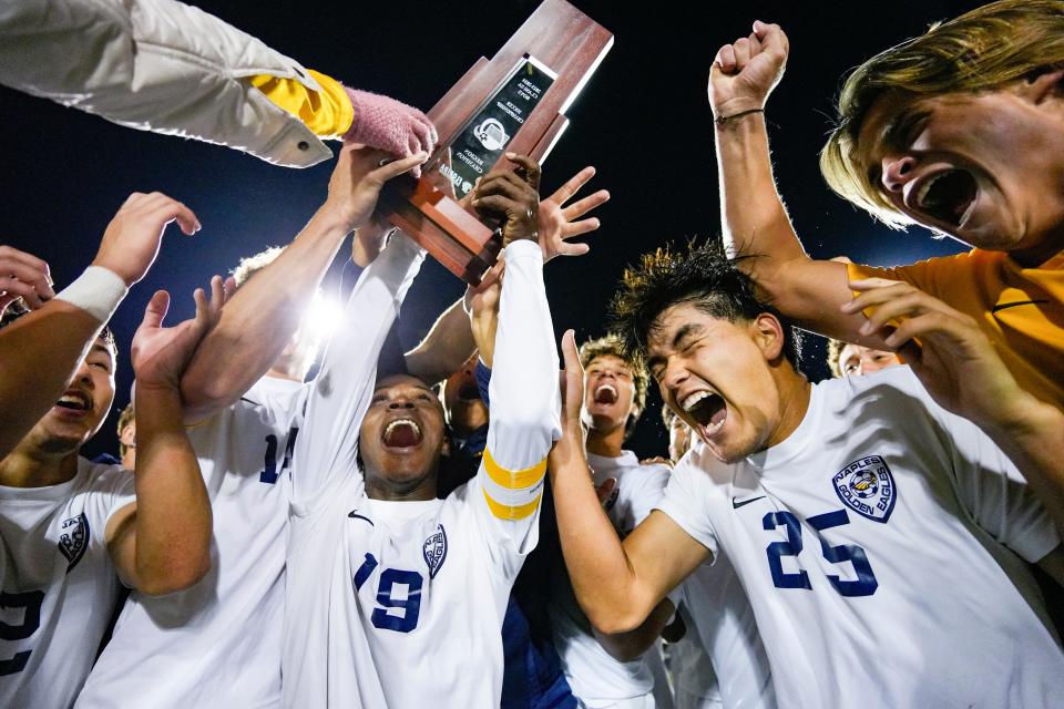 Naples Golden Eagles players celerbate with the trophy after defeating the Barron Collier Cougars in the Class 5A regional final at Barron Collier High School in Naples on Wednesday, Feb. 21, 2024.