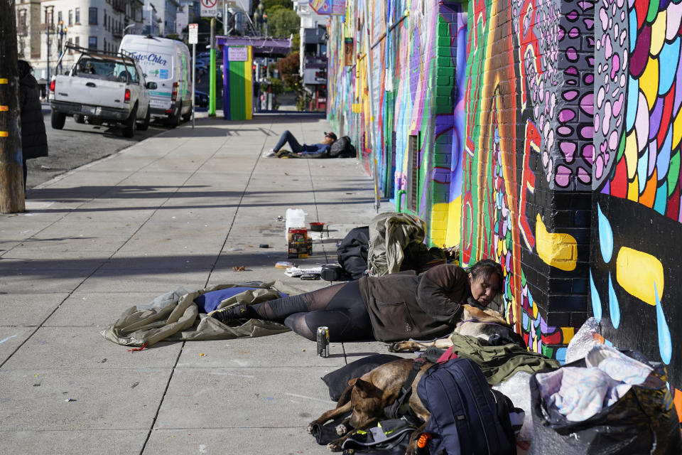 Victoria Solomon pets her dog, Gypsy, as she waits for her belongings to dry in San Francisco, Monday, Dec. 12, 2022. (AP Photo/Godofredo A. Vásquez)