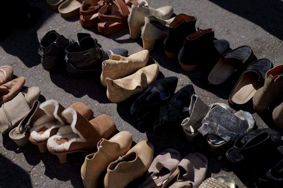 Pairs of shoes lined up on the pavement for sale at Kim Gordon's Closet Sale