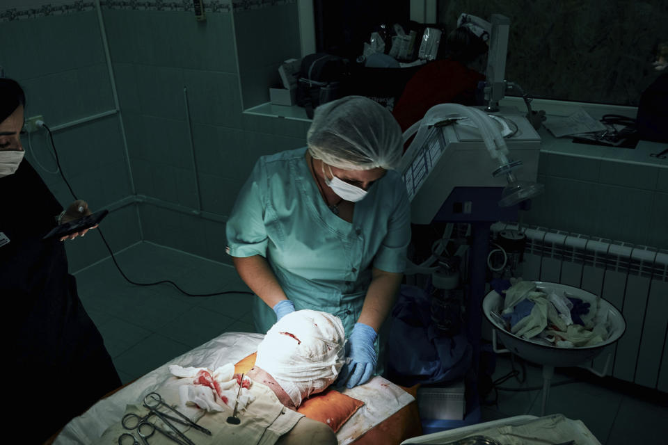 Medics give aid during an operation on a Ukrainian soldier wounded in a battle with the Russian troops in a city hospital in Mykolaiv, Ukraine, Thursday, Nov. 3, 2022. (AP Photo/LIBKOS)