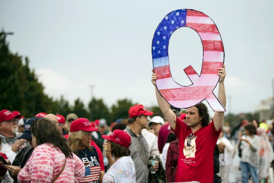 A protester holds a Q sign while waiting in line with others to enter a Trump campaign rally in Wilkes-Barre, Pennsylvania, on 2 August.