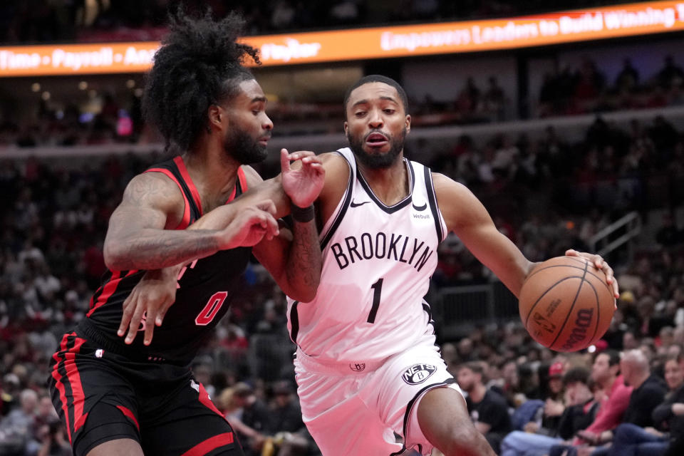 Mikal Bridges (1) de los Nets de Brooklyn conduce hacia el aro superando a Coby White (0) de los Bulls de Chicago durante la 2da mitad del juego del torneo "In-Season" de la NBA el viernes 3 de noviembre de 2023, en Chicago. (AP Foto/Charles Rex Arbogast)