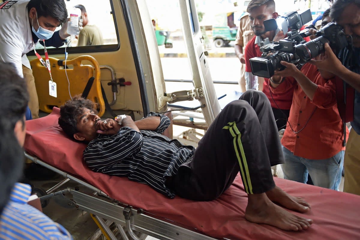 A man is shifted on a stretcher upon arriving in an ambulance at the civil hospital in Ahmedabad on Tuesday after suffering health problems due to consuming bootleg liquor (AFP via Getty Images)