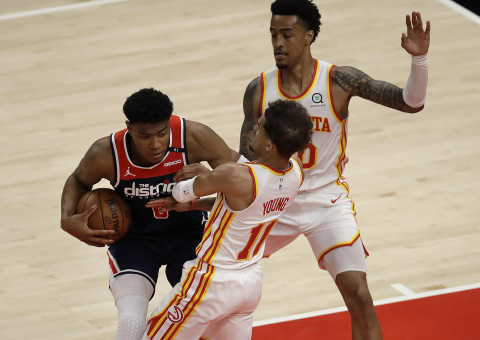 Washington Wizards' Rui Hachimura, left, drives the ball against Atlanta Hawks' Trae Young (11) in the first half of an NBA basketball game Monday, May 10, 2021, in Atlanta. (AP Photo/Ben Margot)
