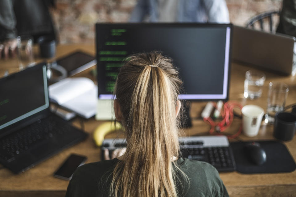 A woman sits in front of a computer at work