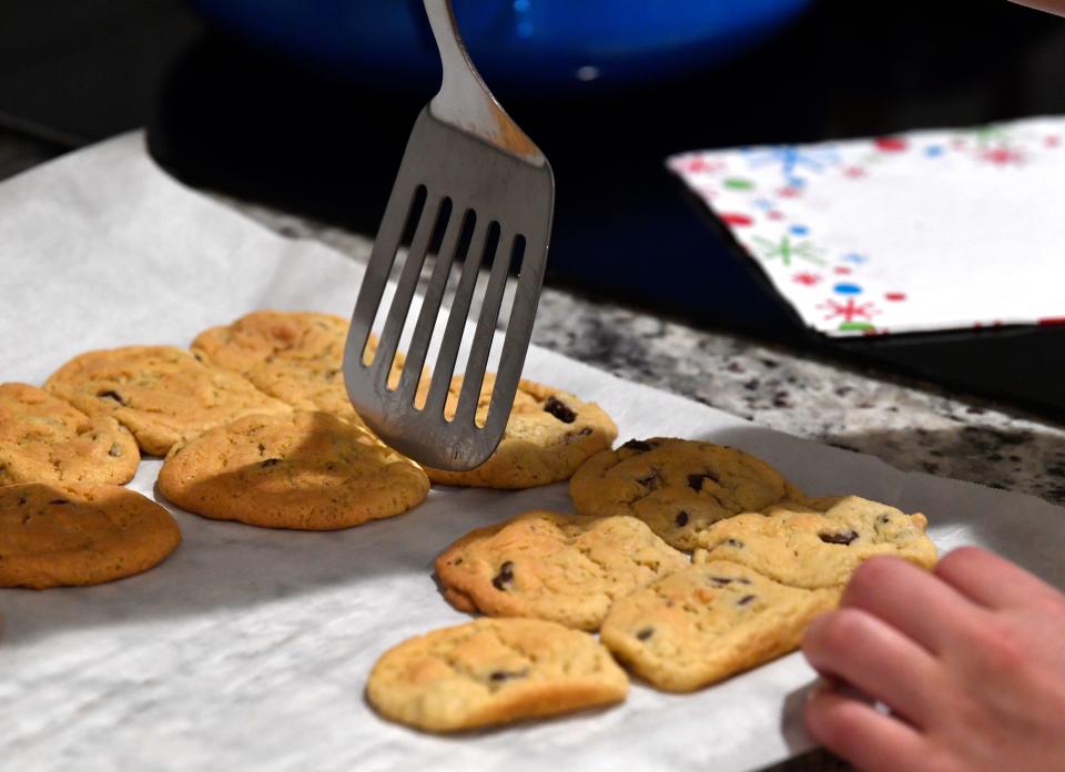 Chloe Forsberg uses a spatula to move her fresh-baked cookies from their metal sheet to a plate Thursday.