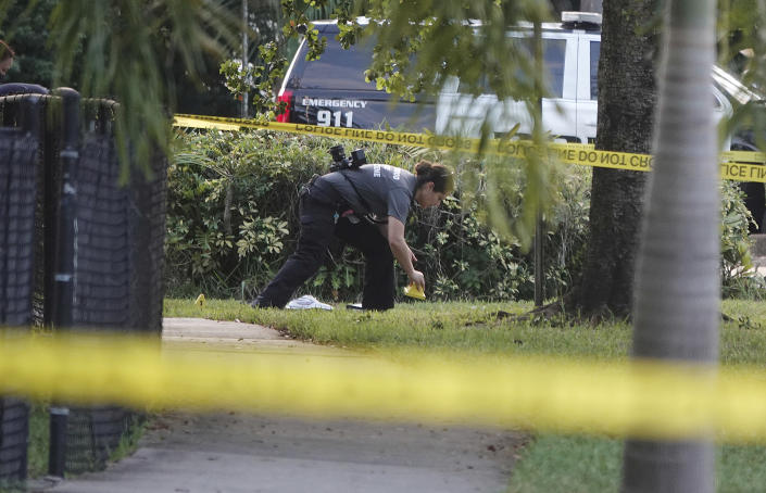 A Hollywood Police crime scene investigator places markers at the scene where officer Yandy Chirino was killed in Hollywood, Fla., Monday Oct. 18, 2021. The officer was killed during a late-night altercation with a teenaged suspect and died at the hospital. (Joe Cavaretta/South Florida Sun-Sentinel via AP)