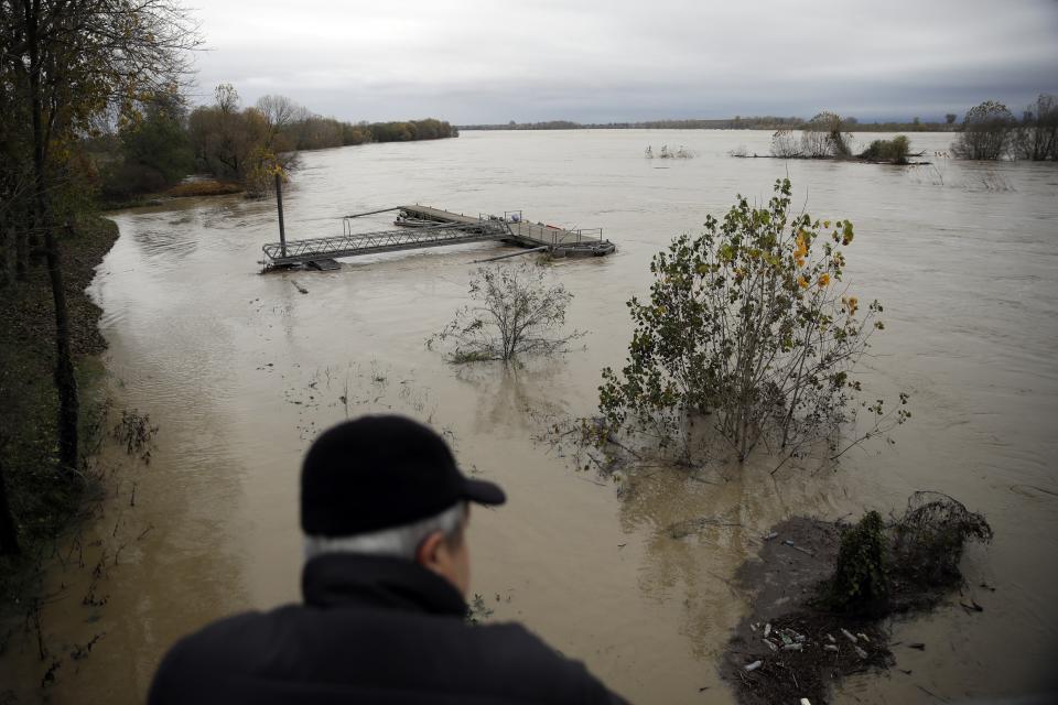 A man watches a swollen Po river in Mezzana Bigli, near Pavia, northern Italy, Sunday, Nov. 24, 2019. Rain-swollen rivers and flooded streets plagued Italy, where it has been raining, sometimes heavily, in much of the country nearly every day for about two weeks. (AP Photo/Luca Bruno)