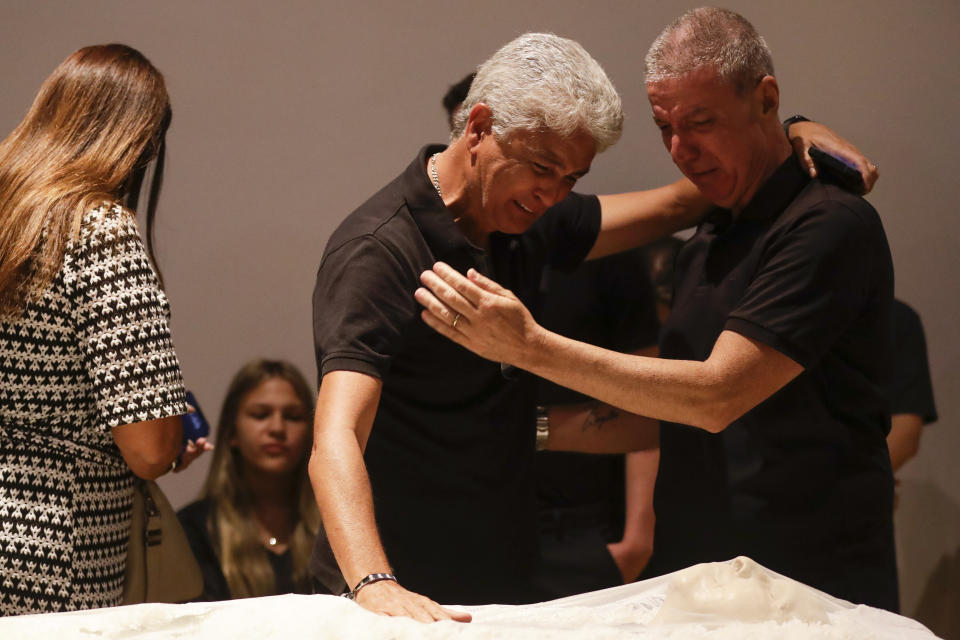 Brazilian former soccer player Bebeto, center, and Mario Cesar Zagallo, left, son of late former Brazilian soccer coach and player Mario Zagallo, pay their final respects during his funeral service at the Brazilian Soccer Confederation headquarters in Rio de Janeiro, Brazil, Sunday, Jan. 7, 2024. Zagallo, who reached the World Cup final a record five times, winning four, as a player and then a coach with Brazil, died at the age of 92. (AP Photo/Bruna Prado)