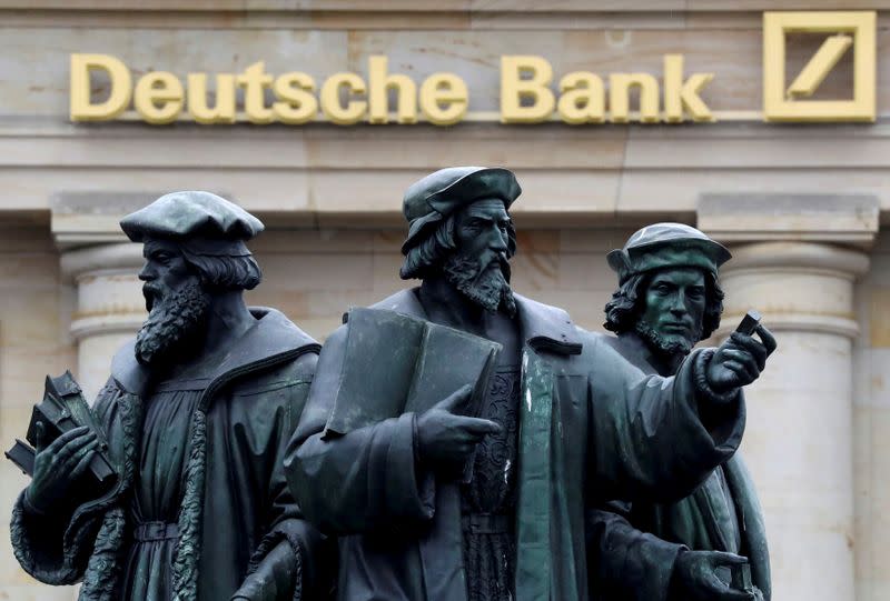 FILE PHOTO: A statue is pictured next to the logo of Germany's Deutsche Bank in Frankfurt