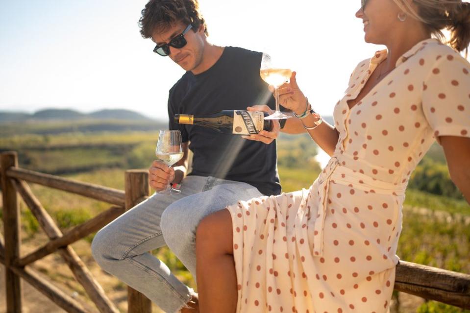 Chica y chico con copas de vino