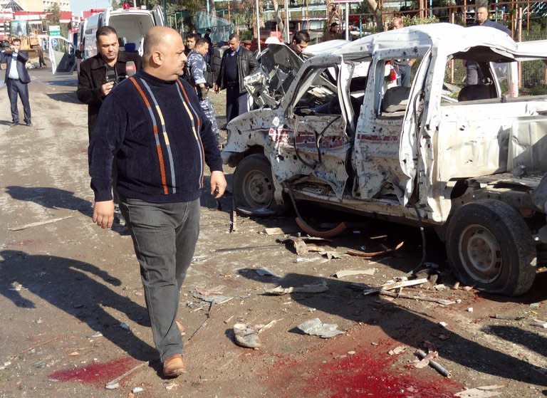 A man walks past the scene after an attack on a police headquarters in Kirkuk. The vehicle that was detonated in central Kirkuk had been painted to look like a police car, and the militants who sought to seize the compound were dressed as policemen, witnesses said