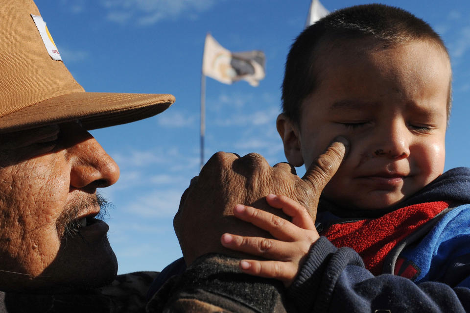 <p>A man named Black Horse holds his grandson during a protest against the Dakota Access pipeline near the Standing Rock Indian Reservation near Cannon Ball, North Dakota, U.S. November 13, 2016. (Photo: Stephanie Keith/Reuters) </p>