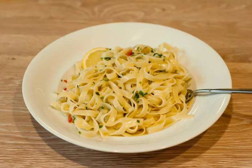 Italian Lemon Pasta or Tagliatelle al Limone on a White Plate with Parsley.