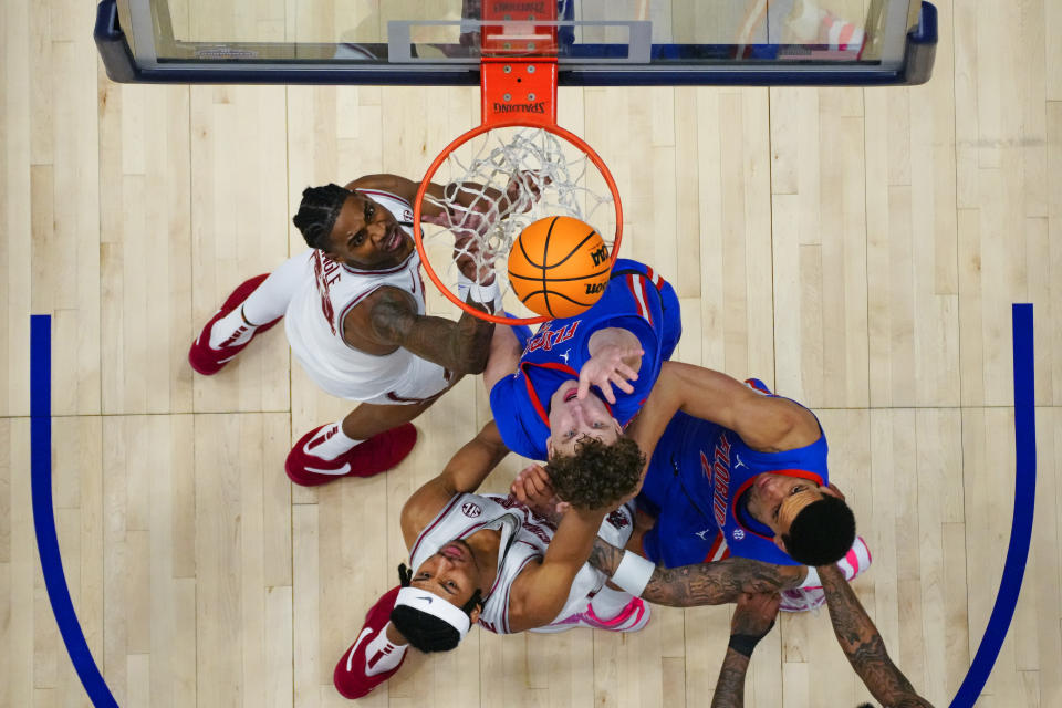 Florida's Micah Handlogten (3) and Riley Kugel (2)' battle Alabama's Nick Pringle (23) and Jarin Stevenson (15) under the basket during the first half of an NCAA college basketball game at the Southeastern Conference tournament Friday, March 15, 2024, in Nashville, Tenn. (AP Photo/John Bazemore)