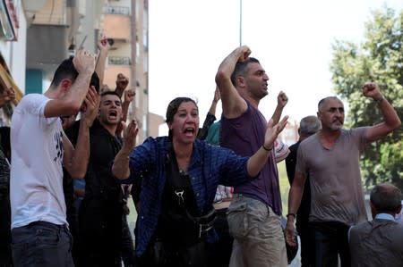 Demonstrators react as police try to disperse them during a protest against the replacement of Kurdish mayors with state officials in three cities, in Diyarbakir