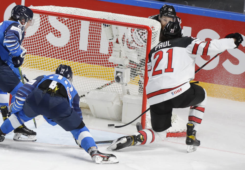 Canada's Nick Paul, right, scores to win the Ice Hockey World Championship final match between Finland and Canada at the Arena in Riga, Latvia, Sunday, June 6, 2021. (AP Photo/Sergei Grits)
