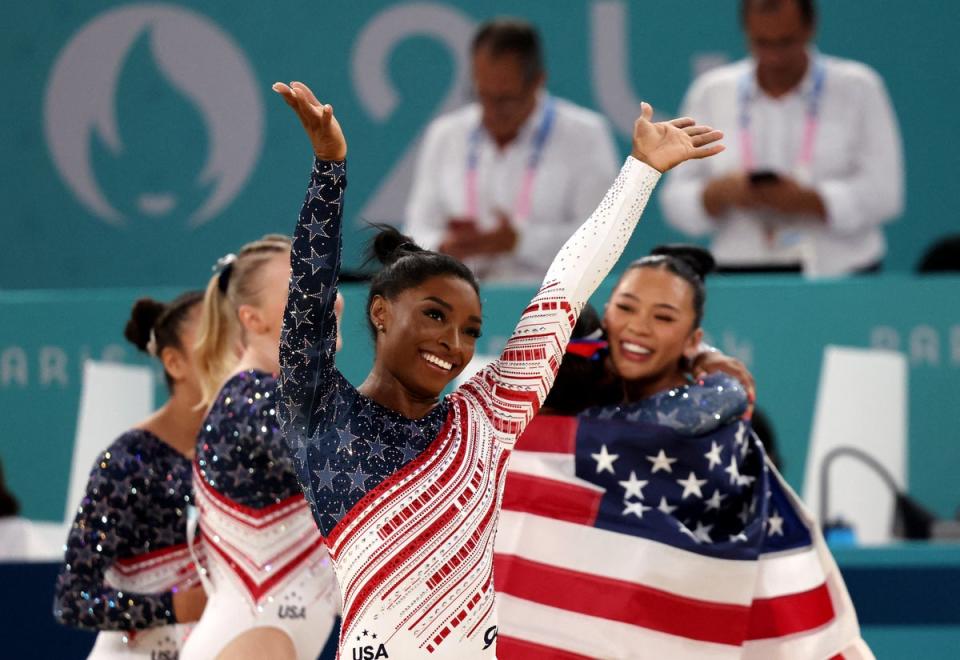 Simone Biles salutes the American fans as her teammates celebrate (Reuters)