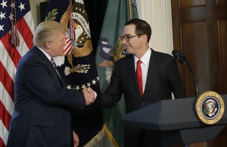 U.S. President Donald Trump (L) greets Treasury Secretary Steven Mnuchin during an event to sign financial services executive orders at the Treasury Department in Washington, U.S., April 21, 2017. REUTERS/Kevin Lamarque