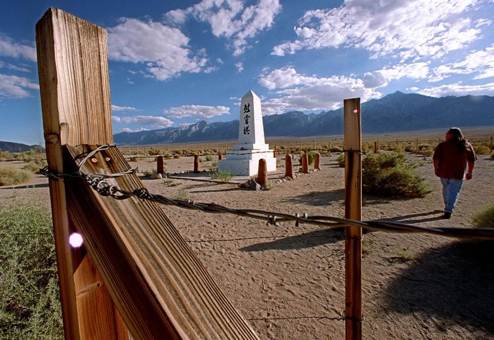 FILE - A man walks through a cemetery on the site of the Manzanar Japanese internment camp near Independence, Calif., on July 24, 1997. The World War II internment camp is featured in a collection of mini-essays by American writers published online by the Frommer's guidebook company about places they believe helped shape and define America. (AP Photo/Damian Dovarganes, File)