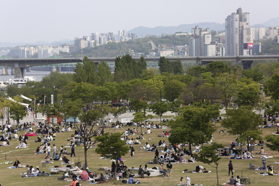 People enjoy at a public park on the Han River in Seoul, South Korea, Thursday, April 30, 2020. South Korean officials on Wednesday issued public pleas for vigilance to maintain hard-won gains against the coronavirus as the nation enters its longest holiday since infections surged in February. (AP Photo/Ahn Young-joon)