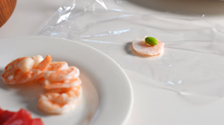 Shrimp and edamame on a piece of plastic wrap