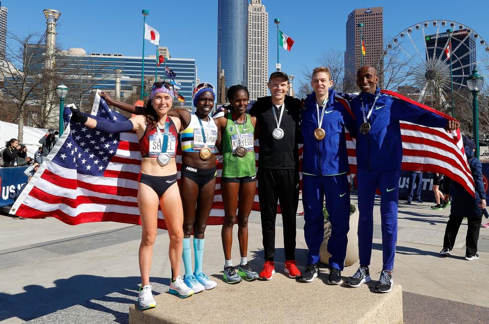 Olympic marathon qualifiers, from left, Molly Seidel, Aliphine Tuliamuk, Sally Kipyego, Jacob Riley, Galen Rupp, and Abdi Abdirahman pose together after finishing in the top three of the men's and women's U.S. Olympic marathon team trials on Feb. 29, 2020, in Atlanta, Georgia.