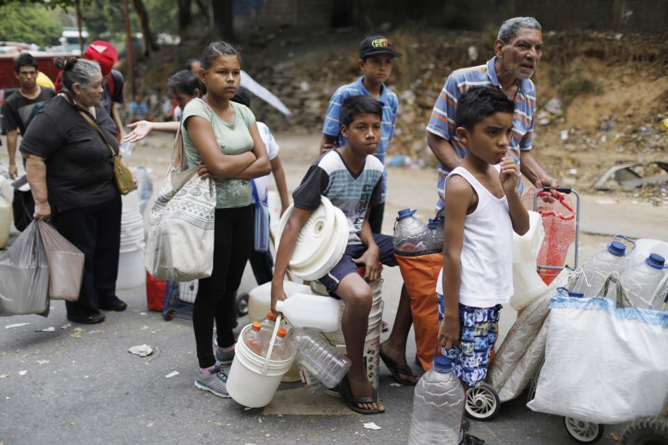 Residents wait in line to fill their containers with water, in Caracas, Venezuela, Monday, April 1, 2019. Since a massive power failure struck March 7, the nation has experienced near-daily blackouts and a breakdown in critical services such as running water and public transportation. (AP Photo/Ariana Cubillos)