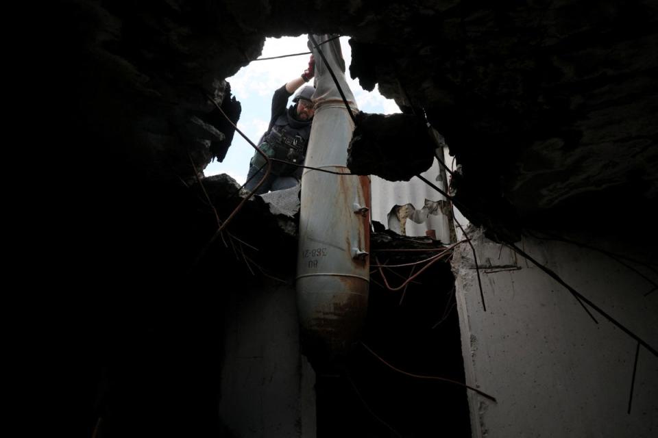 The bomb removal specialists begin removing the explosive from the apartment block (Reuters)