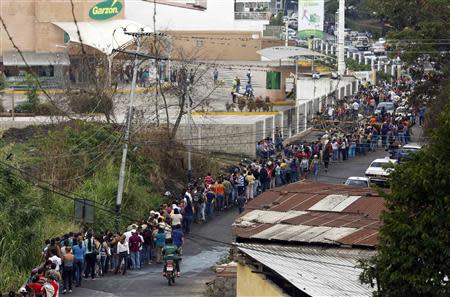 People line up to buy food at a supermarket in San Cristobal, about 410 miles (660 km) southwest of Caracas, February 27, 2014. REUTERS/Carlos Garcia Rawlins
