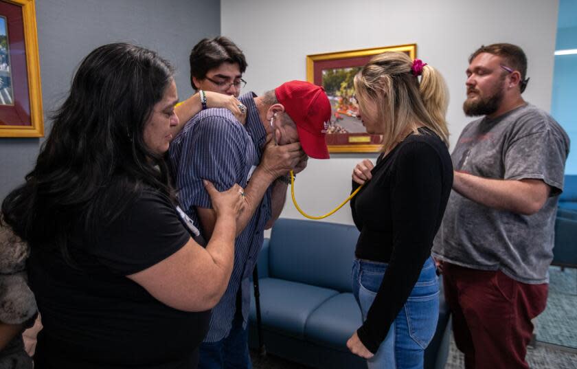 AZUSA, CA - June 29: With a stethoscope, Marco Garcia, left, listens to his son's heart beating inside Alyssa Sauls, right, chest at OneLegacy on June 29, 2023, in Azusa, CA. When Marco Garcia asked to hear the heart of his late son - now beating inside the body of a young mother - OneLegacy hosted a June meeting in a front room at its Azusa facility. Garcia listened, sobbing, through a stethoscope as his son pressed his shoulders and his wife steadied his arm. (Francine Orr / Los Angeles Times)