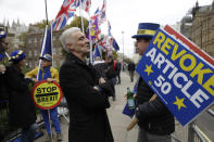 A Brexit supporter, center, speaks to Anti-Brexit remain in the European Union supporter Steve Bray, right, as he protests opposite the Houses of Parliament in London, Thursday, Oct. 17, 2019. EU Brexit negotiator Michel Barnier says that British Prime Minister Boris Johnson told the EU he is confident he can get a deal through the House of Commons. (AP Photo/Matt Dunham)