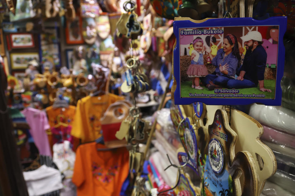 A shellacked image of President Nayib Bukele, his wife Gabriela and their daughter Layla, with a message that reads in Spanish: "A man who lives to serve his people" is displayed for sale in a shop at the Ex-Cuartel market, in San Salvador, El Salvador, Thursday, June 29, 2023. (AP Photo/Salvador Melendez)