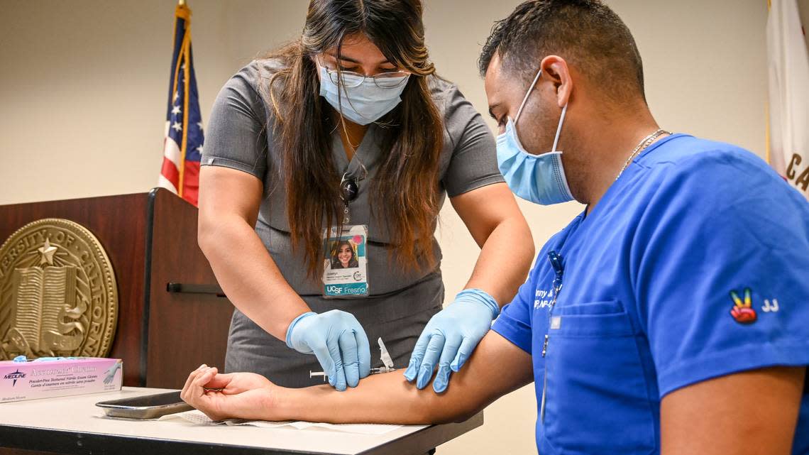 Vaccine support specialist Joselyn Ascencio administers a monkeypox vaccine to nurse practitioner Dr. Johnny Jimenez during a press demonstration at UCSF Fresno’s COVID-19 Equity Project medical clinic in Fresno on Tuesday, Aug. 23, 2022.