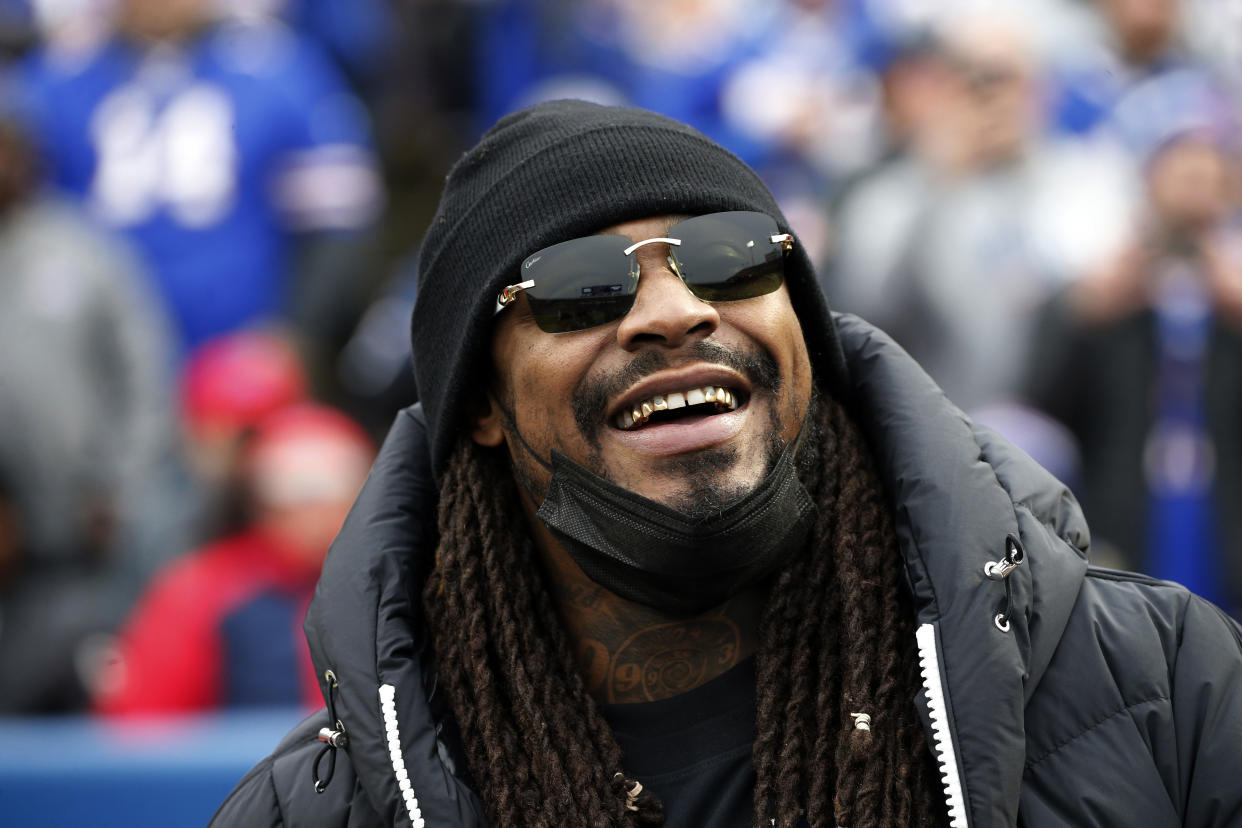 FILE - Marshawn Lynch stands on the field before an NFL football game between the Buffalo Bills and the Indianapolis Colts in Orchard Park, N.Y., Nov. 21, 2021. Police in Las Vegas say the former NFL running back was asleep and smelled of alcohol when he was found in his damaged sports car this week and arrested on suspicion of driving while intoxicated. Lynch's attorneys responded Thursday, Aug. 11, 2022, with a statement saying Lynch was in a parked car, not driving, and a DUI charge won't stick. (AP Photo/Jeffrey T. Barnes, File)