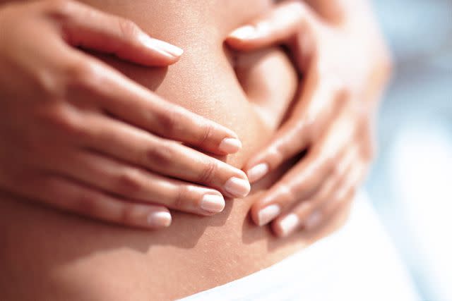 <p>Getty</p> A stock image of a woman holding her stomach