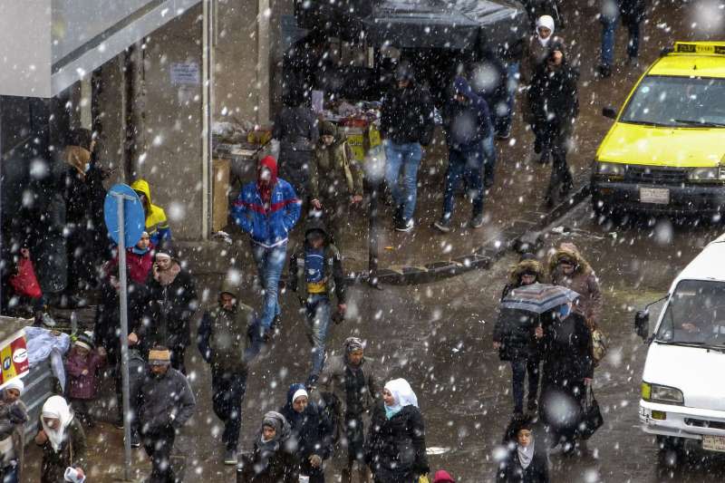 2021年2月，中東下起罕見大雪，圖為敘利亞民眾走在下雪的大馬士革街頭。（AP）