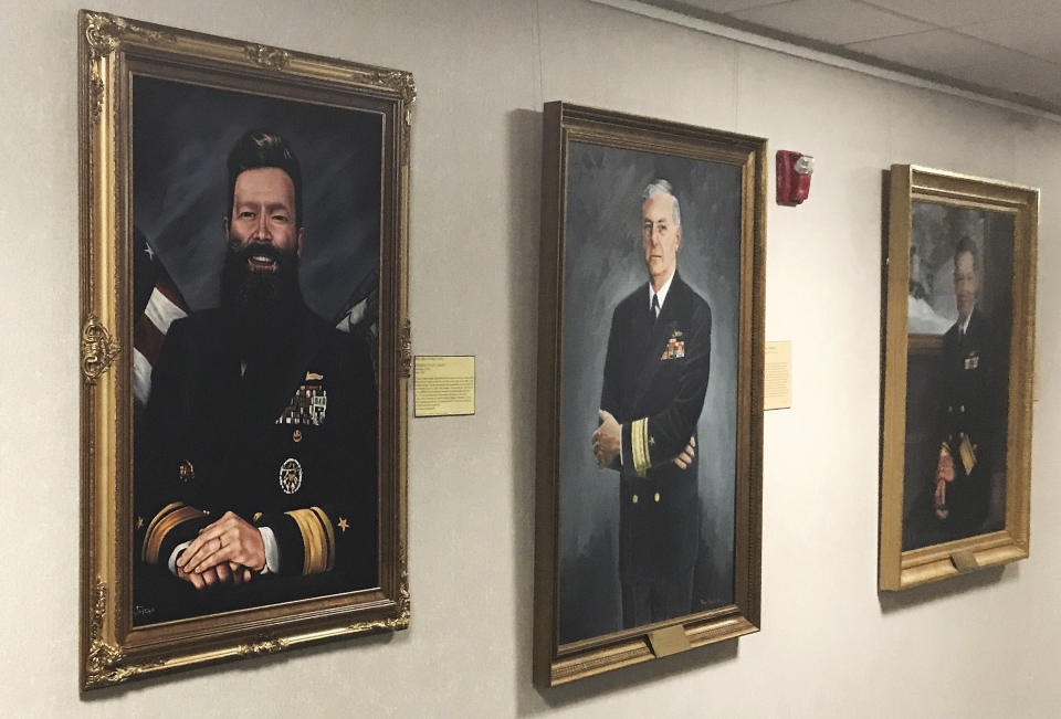 CORRECTION: TAKES OUT REFERENCE OF OFFICIAL ARTIST’S PORTRAIT ADDS INFORMATION ABOUT PORTRAIT: This May 2019 photo provided by U.S. Naval War College president Rear Adm. Jeffrey Harley, shows a portrait of Harley, left, displayed in a gallery in Conolly Hall on the school's campus in Newport, R.I. Harley, who is bald, said the portrait was made by a professor who paid for it himself and gave it to Harley as a joke. He called it a way to poke fun of himself. Dozens of emails, which span from December 2017 to May 2019, were shared with The Associated Press by people at the war college who said they were concerned about Harley's leadership and judgment. (Rear Adm. Jeffrey Harley/U.S. Naval War College via AP)