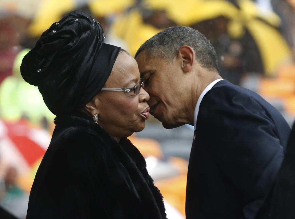 President Barrack Obama kisses Nelson Mandela's widow Graca Machel during the memorial service for former South African president Nelson Mandela at the FNB Stadium in Soweto near Johannesburg, Tuesday, Dec. 10, 2013. (AP Photo/Matt Dunham)