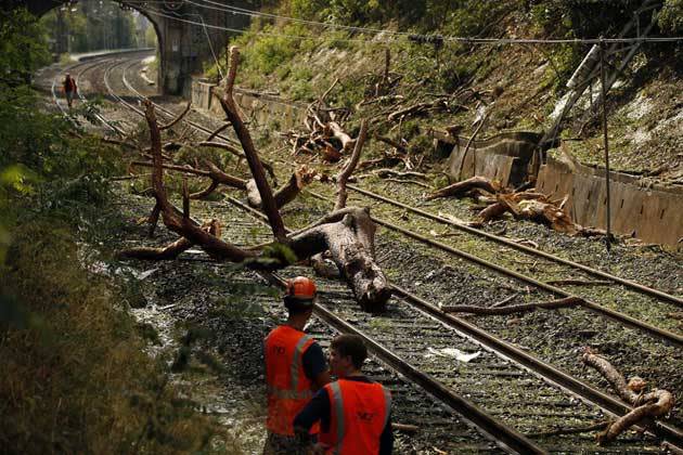 Bahnmitarbeiter und Polizisten räumen die Schienen nahe Saint-Aunès im Süden Frankreichs. Ein Regionalzug wurde auf der Strecke zwischen Nîmes und Montpellier von einem herabfallenden Baum getroffen. Acht der 250 Passagiere wurden dabei verletzt. (Bild: Guillaume Horcajuelo/EPA)