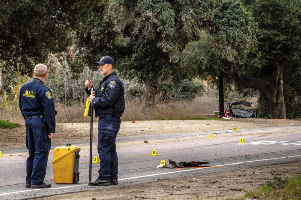 Officers with the California Highway Patrol's (CHP) Multidisciplinary Accident Investigation Team (MAIT) investigate the scene of a deadly crash in the Temescal Valley, south of Corona, Calif., Monday, Jan. 20, 2020. A Southern California driver intentionally rammed a Toyota Prius with several teenage boys inside, killing a few and injuring a few others before fleeing, authorities said Monday. (Watchara Phomicinda/The Orange County Register via AP)