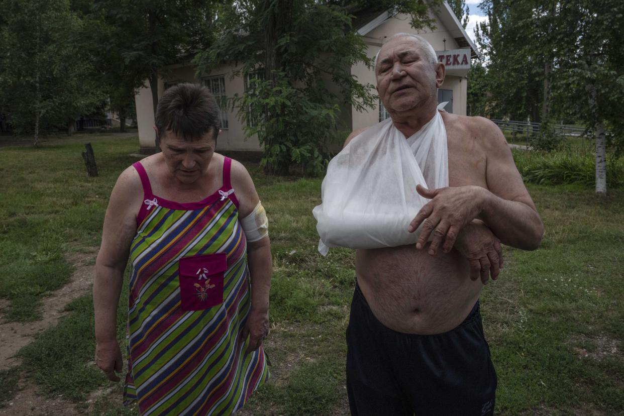 Mykola Zavodovskyi, right, and Tetiana Zavodovska, injured from a rocket attack that hit a five-story building, receive treatment at a hospital, in Kramatorsk, eastern Ukraine, Tuesday, July 19, 2022. (AP Photo/Nariman El-Mofty)