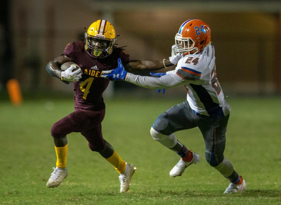 Glades Central Shaborne Demps stiff arms Palm Beach Gardens Aiden Malcolm during their game in Belle Glade, Florida on September 3, 2021. 