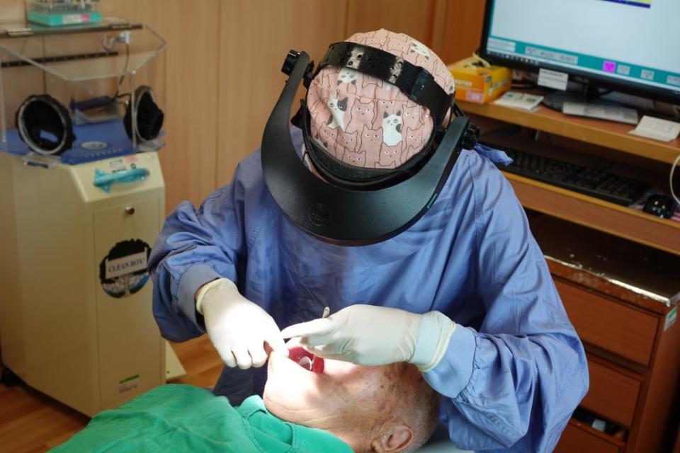 醫師林冠佩為病人的全口假牙印製初模。（記者徐義雄攝）