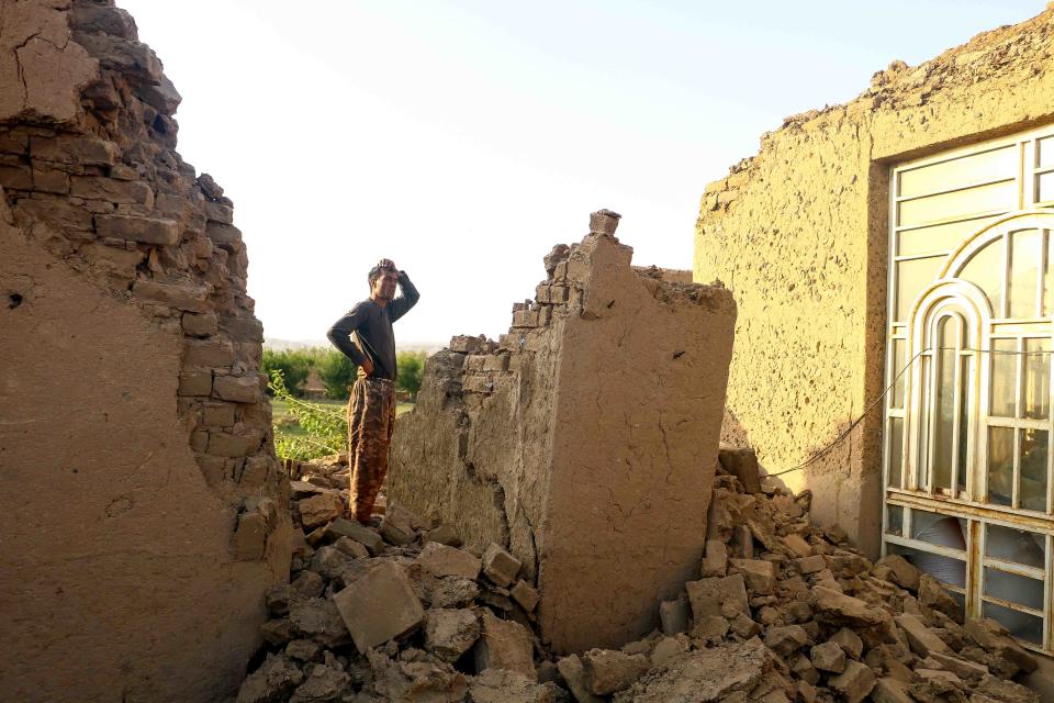 An Afghan man stands in the ruins of a house destroyed by the earthquake.. A magnitude 6.3 earthquake killed two people in western Afghanistan on October 14, resulting in damaged prisons being emptied and residents fleeing a region where tremors have claimed at least 1,000 lives over the past week.