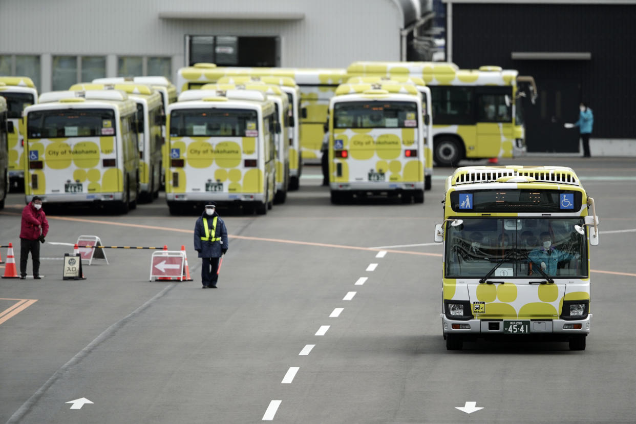 Buses carrying the passengers from the quarantined Diamond Princess cruise ship leave a port in Yokohama, near Tokyo, Wednesday, Feb. 19, 2020. Passengers tested negative for COVID-19 started disembarking Wednesday. (AP Photo/Eugene Hoshiko)